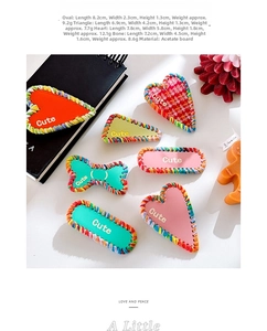 Flat lay of diverse acetate hair clips with woven edges and Cute lettering detail