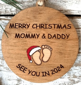Detail view of round wooden Christmas ornament for mommy and daddy with 2024 footprints