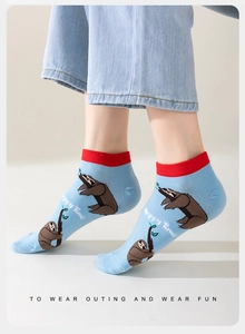 Close-up of blue cotton ankle socks featuring a cute sloth pattern and red ribbed cuffs