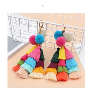 Close-up of bohemian layered colorful tassels with pom poms and a gold lobster clasp