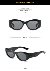 Close-up of black oval sunglasses featuring triple gold rivets and polished finish