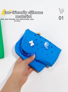 Blue silicone pencil case detail with cartoon whale and bow charms in hand
