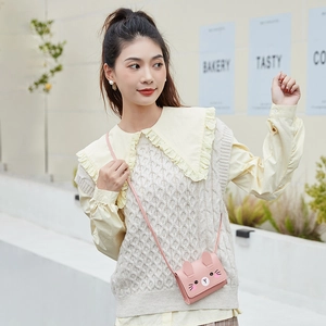 Pink mini crossbody bag with cartoon bunny design shown in an outdoor cafe setting