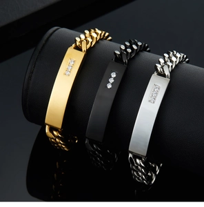 Detailed view of three stainless steel Cuban link bracelets in gold, silver, and black finishes