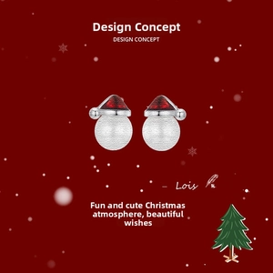 Macro detail of Christmas hat stud earrings with red enamel and frosted silver texture