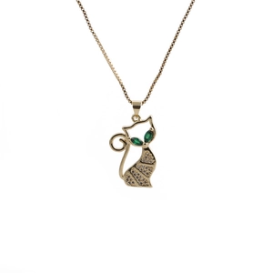 Detail of gold cat pendant with green gemstone eyes and clear crystals on a titanium chain