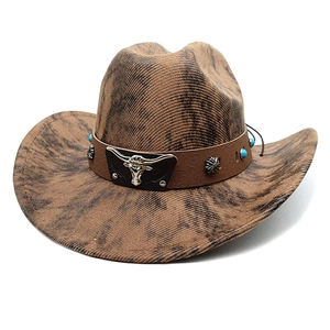 Detail of a brown western cowboy hat with a silver bull head and turquoise beads