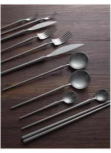Flat lay of retro matte gray 304 stainless steel cutlery set on dark wood background