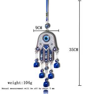 Detailed view of Hamsa Hand and Evil Eye wall hanging with dimensions and blue bells