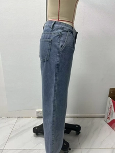 Detail view of high-waisted wide-leg jeans in medium blue wash on a display mannequin