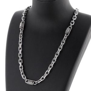 Detail of silver biker chain necklace with spring accents on black mannequin