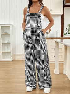 Detail of checkered maternity overalls showing strap buckles and side pockets in a kitchen