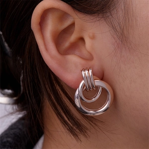 Close-up of rose gold double hoop earrings worn by a model showcasing high-polish finish