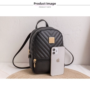 Detailed macro view of black V-quilted small backpack with a golden metal logo plate