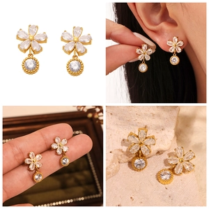 Vue détaillée de boucles d'oreilles fleur or 18 carats avec pierres zircon 5A et cristaux