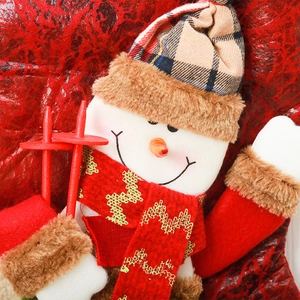 Close-up of plush snowman ornament with brown plaid hat and red scarf for Christmas tree
