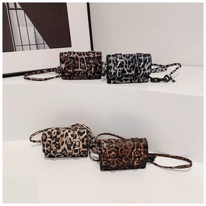 Collection of four animal print mini square crossbody bags on a white stepped display stand