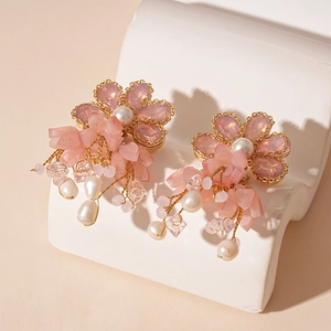 Pink flower petal drop earrings with freshwater pearls and tassels on a white display