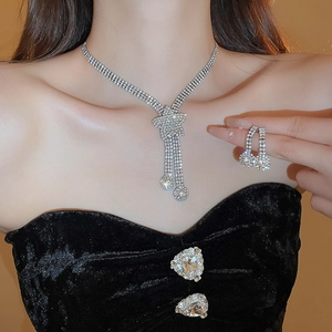 Close-up of luxury rhinestone star tassel necklace and earring set on model in evening gown