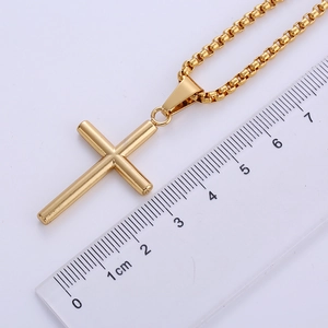 Detail view of 18k gold plated stainless steel cross pendant showing 4.5cm length on ruler