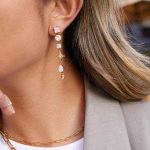 Elegant gold drop earrings with zircon crystals shown on model in natural outdoor light