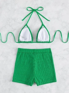 Detailed top view of neon green ribbed bikini with adjustable halter top and high waist shorts