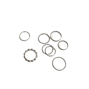 Minimalist silver metal ring set featuring eight unique geometric and textured designs