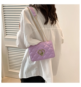 Détail du sac bandoulière matelassé violet avec fermoir cœur et chaîne dorée