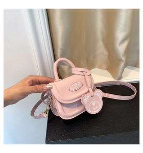 Pink mini crossbody bag featuring a cute bear charm and a HELLO decorative plaque