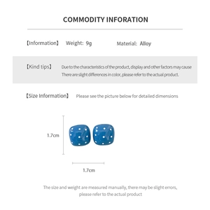 Blue square stud earrings with white polka dots and size details in a macro shot