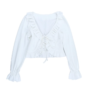 Détail d'un cardigan blanc court avec bords à volants et fermeture à nouer devant