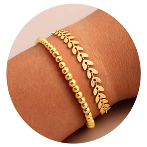 Detail von mehrlagigen vergoldeten Messingarmbändern mit Perlen und Blattmuster