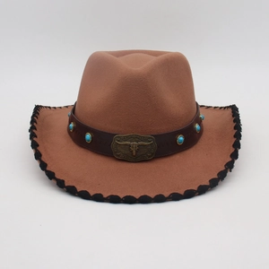 Dettaglio cappello da cowboy marrone con fascia in pelle, borchie turchesi e fibbia a testa di toro