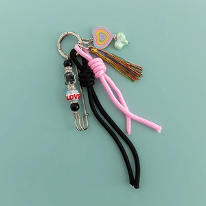 Detail of pink and black woven rope keychain with rhinestone tassels and LOVE beads