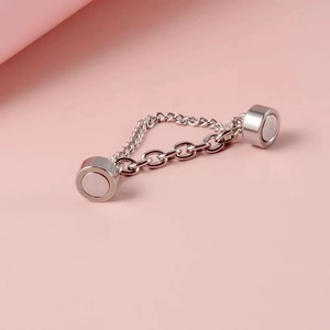 Silver magnetic non-piercing chain ear clips on minimalist pale pink background