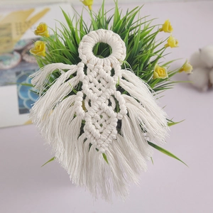 Close-up of bohemian handmade woven cotton rope wall hanging with tassel details