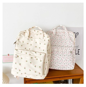 Floral backpack detail showing polyester canvas texture and vintage flower patterns on cream base