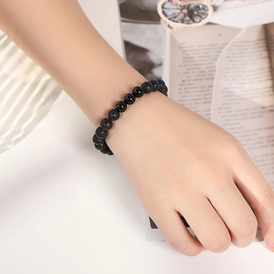 Close-up of 8mm natural tiger eye and lava stone beaded bracelets on a model's wrist