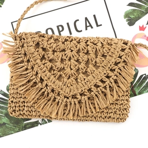 Mini straw woven shoulder bag with tassel fringe and thin strap in camel color