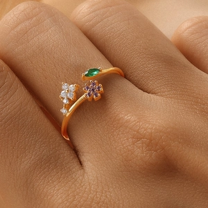 Macro detail of S925 silver floral ring with purple gems and green leaf on finger