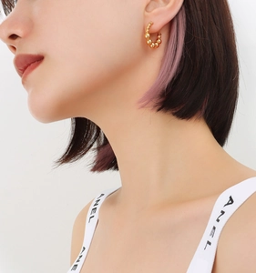 Close-up of elegant gold beaded hoop earrings worn by a model for a stylish look