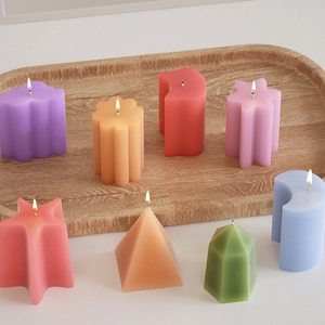 Bougies d'aromathérapie géométriques aux formes variées sur plateau en bois
