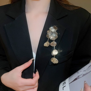 Close-up of a gold floral tassel brooch with rhinestones on a black suit lapel