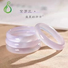 Detailed stack of four violet chalcedony stone bangles on beige fabric with soft lighting