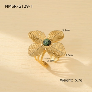 Detailed view of flower-shaped titanium ring with green gemstone and adjustable triple band