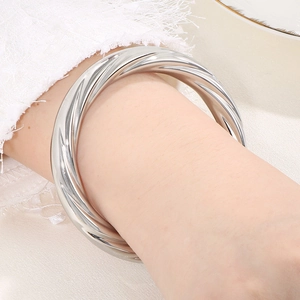 Detailed view of silver spiral textured cuff bracelet worn on wrist with elegant lace decor