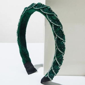 Dettaglio del cerchietto in velluto verde con strass smeraldo e cristalli d'argento lucidi