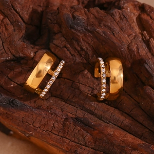 Vue macro de boucles d'oreilles C à double couche dorées avec cristaux micro-pavés