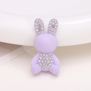 Detailed macro view of a purple resin rabbit charm with sparkling inlaid rhinestones