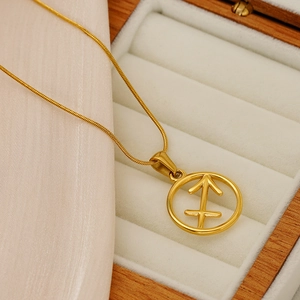 Detail of a 18K gold Sagittarius zodiac pendant with a fine snake chain in a gift box